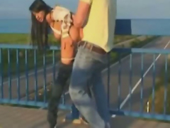 Грудастая темноволосая красотка занимается сексом со своим парнем на середине моста